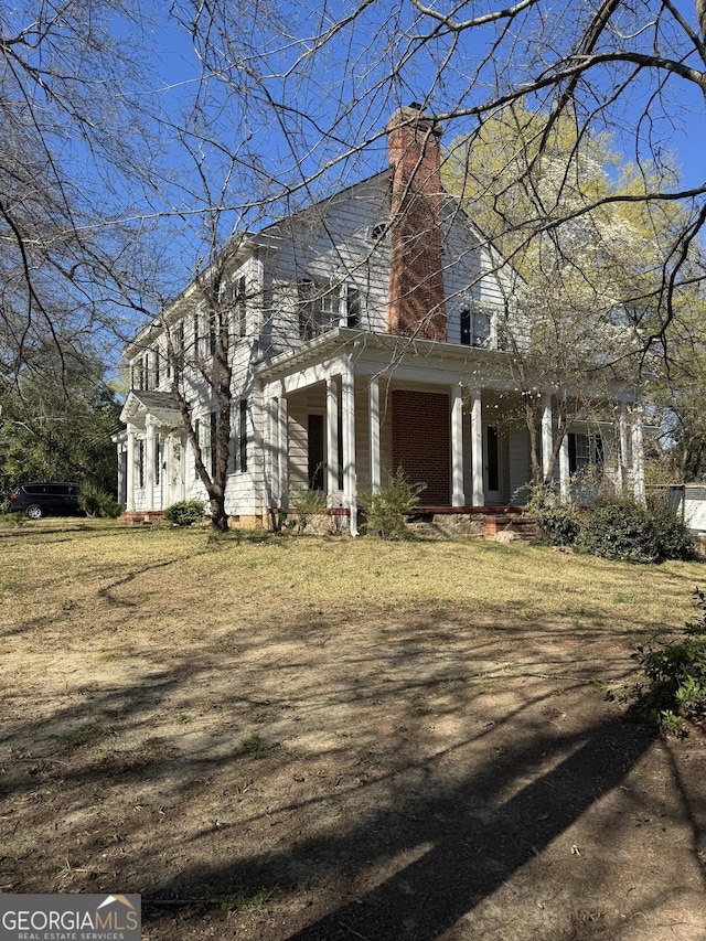 view of front of home with covered porch and a chimney