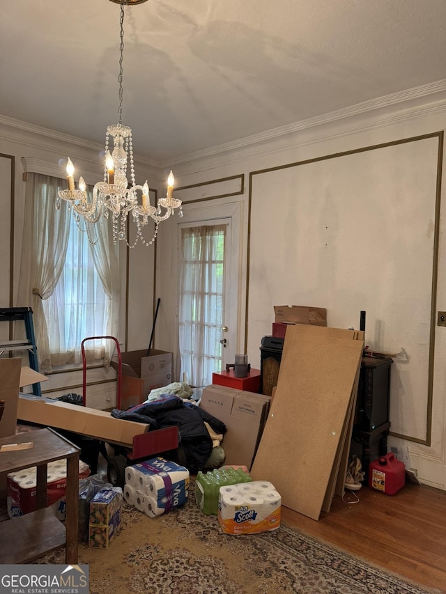 dining room with crown molding, a notable chandelier, and wood finished floors
