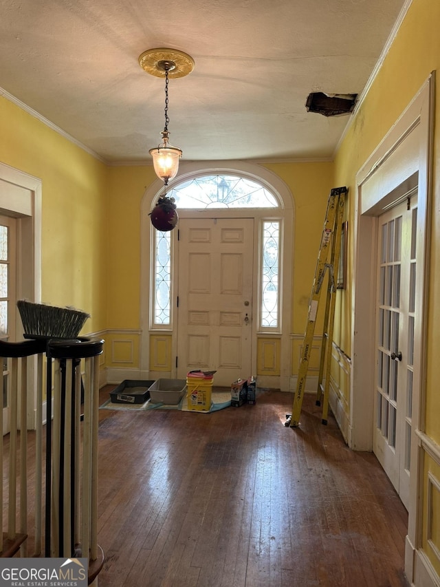 entryway featuring french doors, plenty of natural light, ornamental molding, and hardwood / wood-style flooring