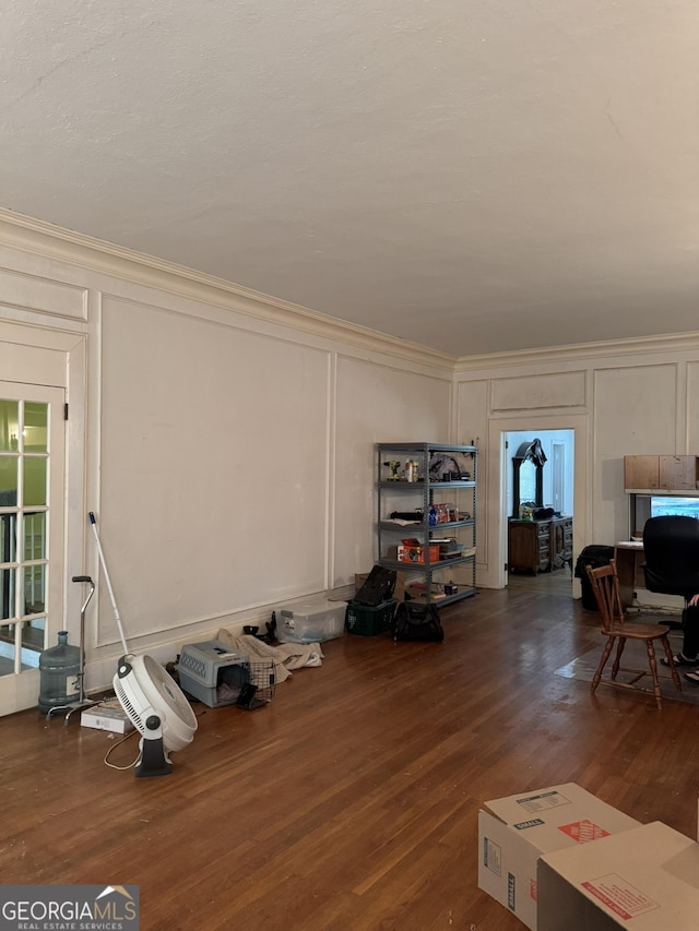 living room featuring a healthy amount of sunlight, ornamental molding, and a decorative wall