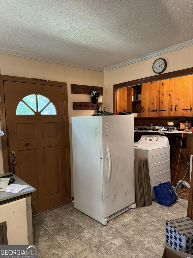 interior space with washer / dryer, a textured ceiling, ornamental molding, and cabinet space