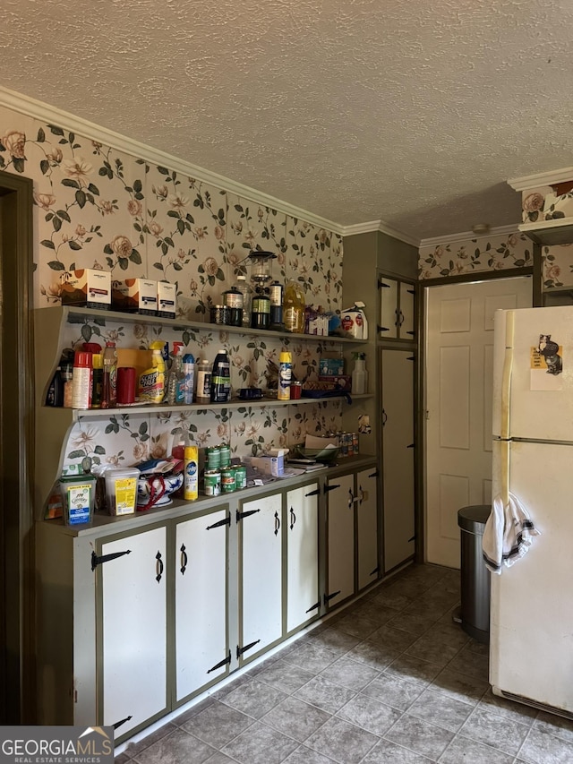 bar with crown molding, freestanding refrigerator, a textured ceiling, and light tile patterned floors