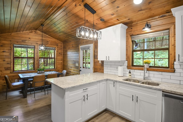 kitchen featuring sink, white cabinetry, stainless steel dishwasher, pendant lighting, and light stone countertops