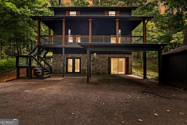 back house at dusk with a wooden deck