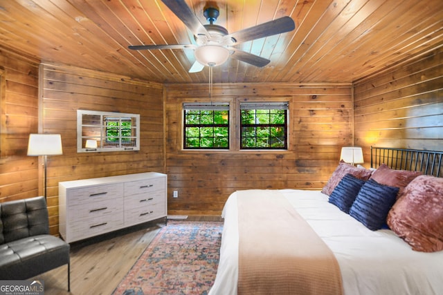 bedroom featuring wood ceiling, wooden walls, and light wood-type flooring