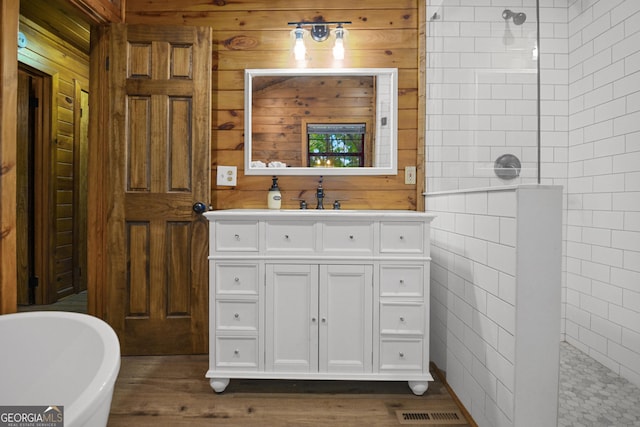 bathroom featuring vanity, hardwood / wood-style floors, independent shower and bath, and tile walls