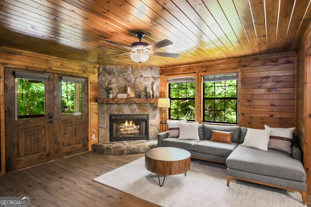 living room featuring hardwood / wood-style flooring, a wealth of natural light, wooden ceiling, and wood walls