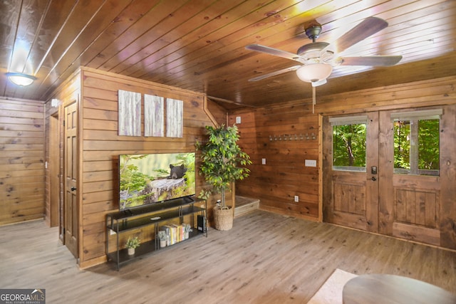 interior space featuring hardwood / wood-style floors, wooden walls, wooden ceiling, and ceiling fan