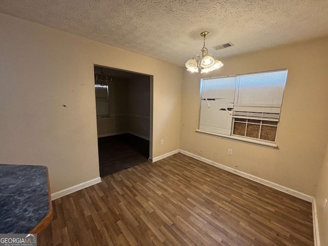 40 Brandon Dr, Covington, GA 30016 - unfurnished room with dark wood-type flooring, an inviting chandelier, and a textured ceiling