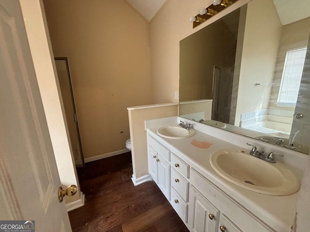 40 Brandon Dr, Covington, GA 30016 - bathroom featuring a washtub, lofted ceiling, hardwood / wood-style floors, vanity, and toilet