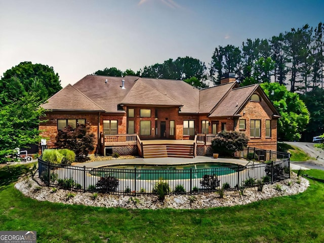 view of pool with a lawn and a deck