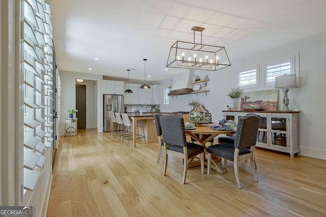 dining area featuring sink, light hardwood / wood-style flooring, and a healthy amount of sunlight