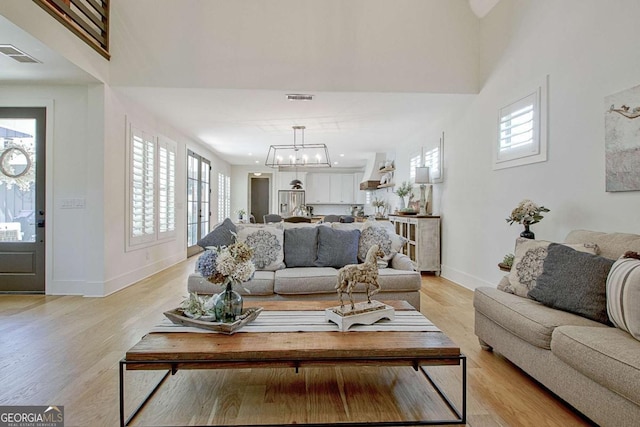 living room featuring a notable chandelier and light wood-type flooring