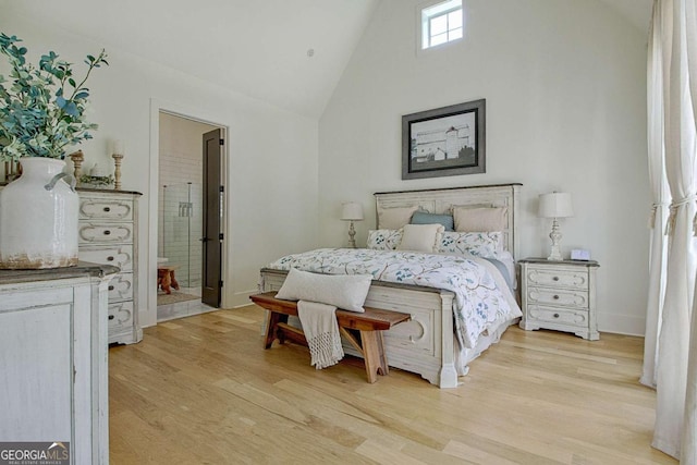 bedroom with connected bathroom, high vaulted ceiling, and light wood-type flooring