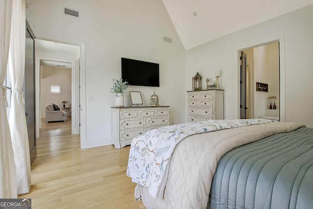 bedroom featuring high vaulted ceiling and light wood-type flooring