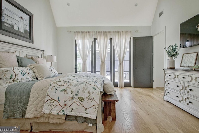 bedroom with high vaulted ceiling and light hardwood / wood-style floors