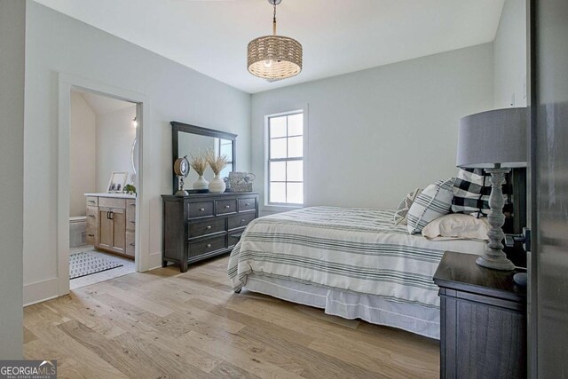 bedroom featuring light hardwood / wood-style floors and ensuite bathroom