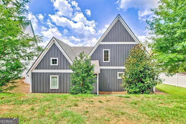 rear view of property featuring a lawn