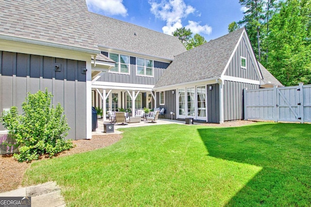 back of property with an outdoor living space, a yard, and a patio