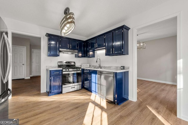 kitchen featuring sink, light wood-type flooring, stainless steel appliances, and blue cabinetry