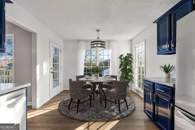 dining room with dark hardwood / wood-style floors, a chandelier, and a textured ceiling