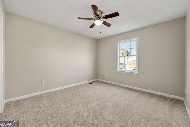 carpeted spare room featuring ceiling fan