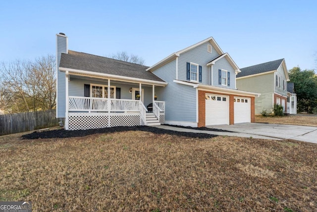 front facade featuring a garage, a front yard, and covered porch