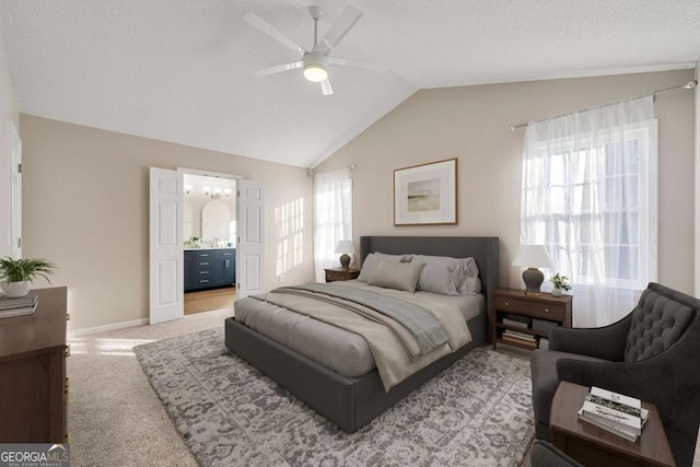 bedroom with connected bathroom, lofted ceiling, light colored carpet, ceiling fan, and a textured ceiling