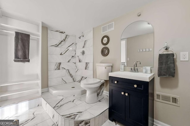 bathroom featuring tiled shower, vanity, and toilet