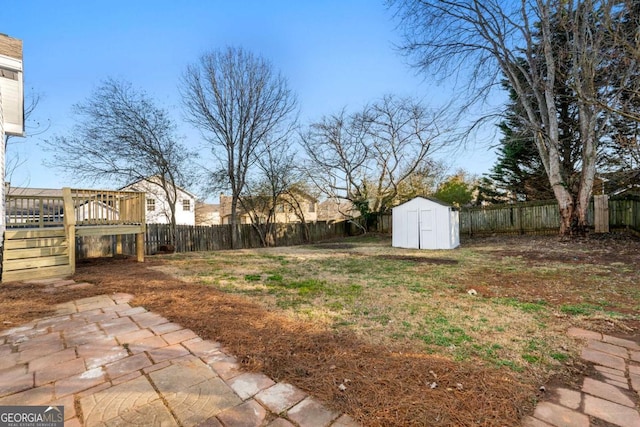 view of yard featuring a wooden deck and a shed