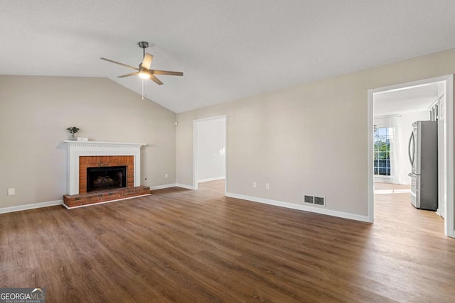 unfurnished living room with dark hardwood / wood-style floors, ceiling fan, lofted ceiling, and a fireplace