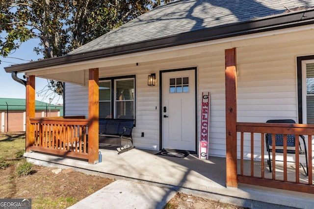 view of exterior entry featuring covered porch