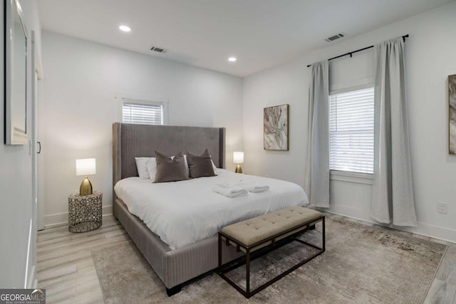 bedroom featuring multiple windows and light hardwood / wood-style flooring