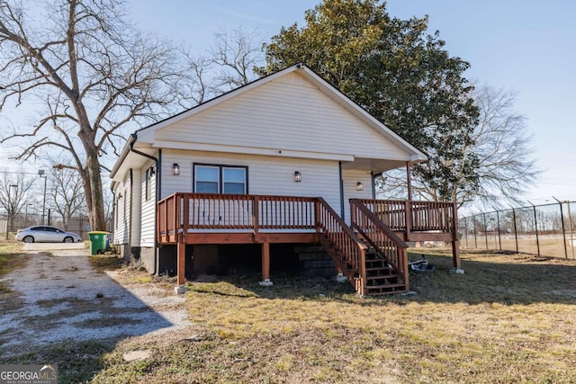 back of property with a deck and a lawn