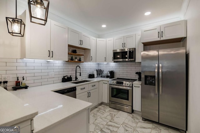 kitchen with appliances with stainless steel finishes, sink, pendant lighting, and white cabinets