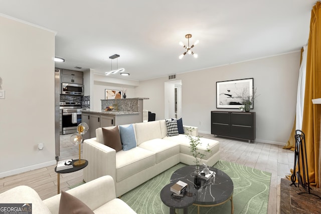 living room with an inviting chandelier, crown molding, and light hardwood / wood-style floors