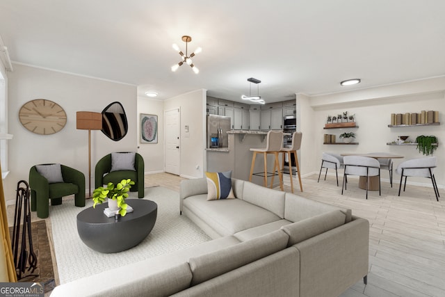 living area with crown molding, a notable chandelier, baseboards, and light wood finished floors