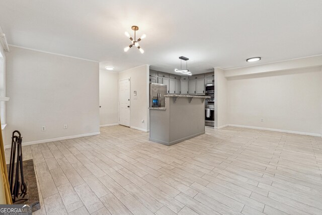 kitchen with pendant lighting, stainless steel appliances, light hardwood / wood-style floors, and backsplash