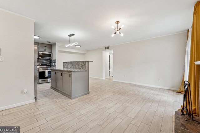 kitchen featuring gray cabinets, appliances with stainless steel finishes, hanging light fixtures, light stone counters, and tasteful backsplash