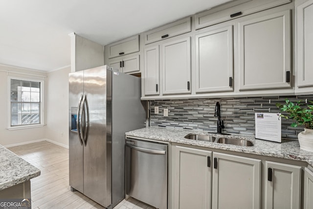 kitchen with sink, backsplash, stainless steel appliances, and light stone countertops