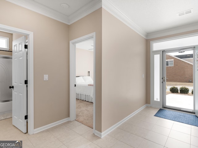 foyer featuring ornamental molding, a wealth of natural light, and visible vents