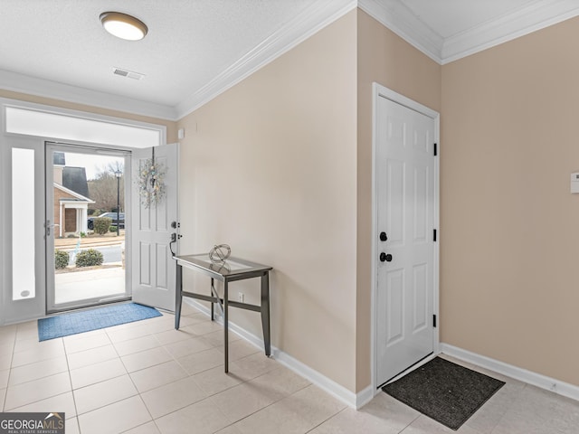 entryway with light tile patterned floors, baseboards, visible vents, and ornamental molding