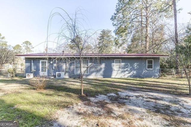 back of property featuring ac unit and a yard