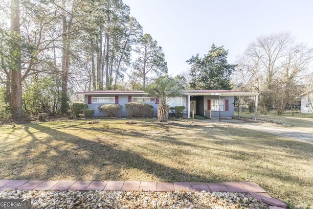 ranch-style home featuring a carport and a front yard