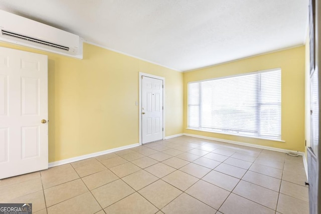 spare room featuring light tile patterned floors and an AC wall unit