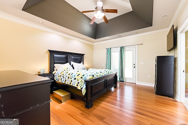 bedroom with a raised ceiling, ornamental molding, and light hardwood / wood-style floors