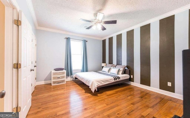 bedroom featuring ornamental molding, light hardwood / wood-style flooring, and a textured ceiling