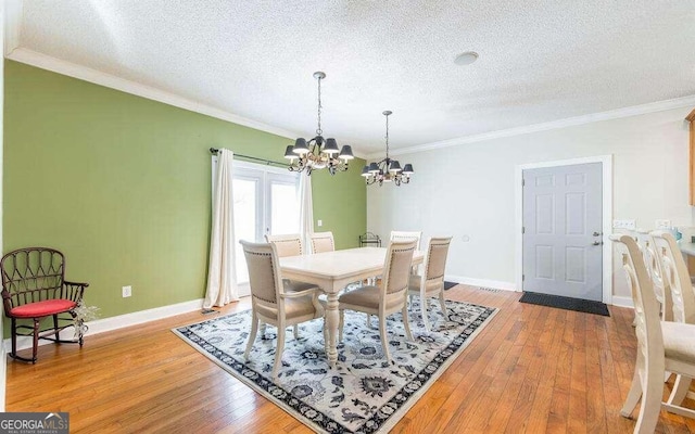 dining room with crown molding, hardwood / wood-style floors, and a chandelier