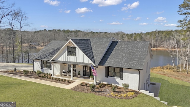 back of house featuring a water view, a yard, and a patio