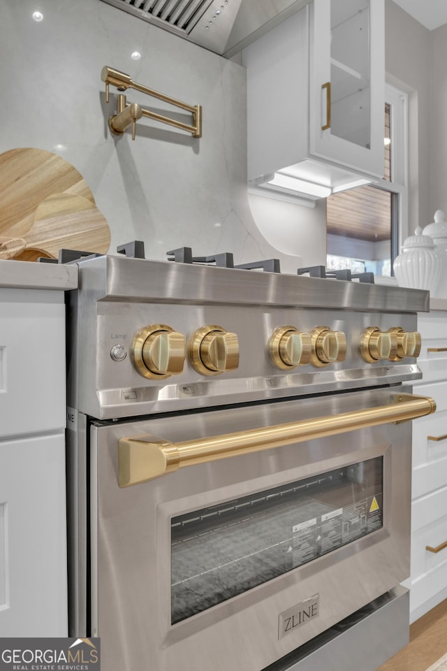 interior details with white cabinetry and stainless steel stove